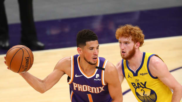 Mar 4, 2021; Phoenix, Arizona, USA; Phoenix Suns guard Devin Booker (1) against Golden State Warriors guard Nico Mannion (2) at Phoenix Suns Arena. Mandatory Credit: Mark J. Rebilas-USA TODAY Sports